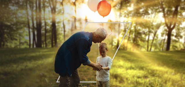 Grandfather and grandson with balloons in park